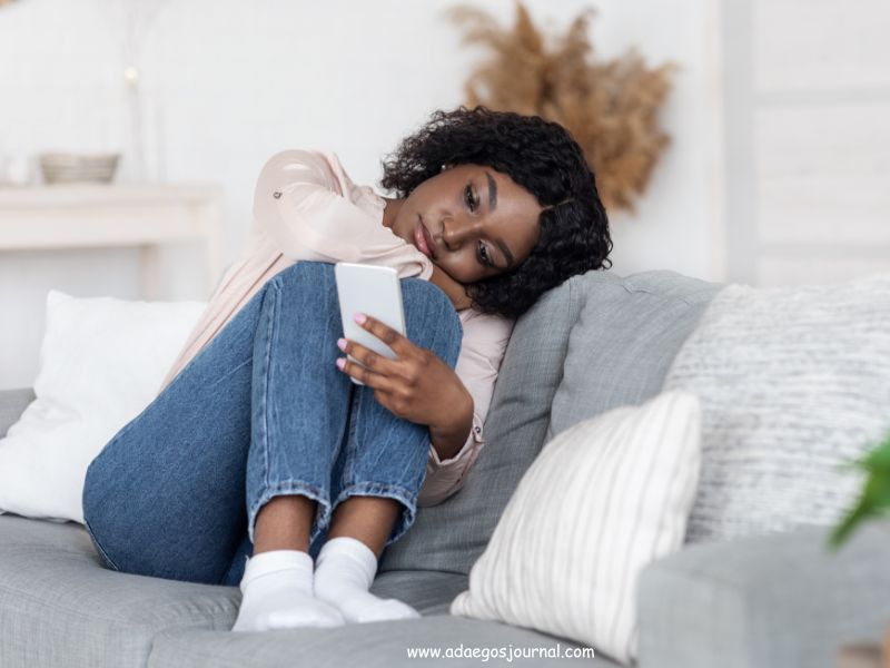 A-woman-scrolling-phone-alone-on-a-couch.