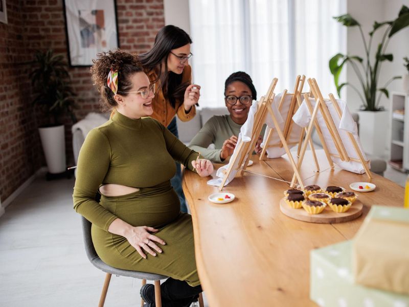 Creative baby shower activity where guests decorate onesies with fabric markers