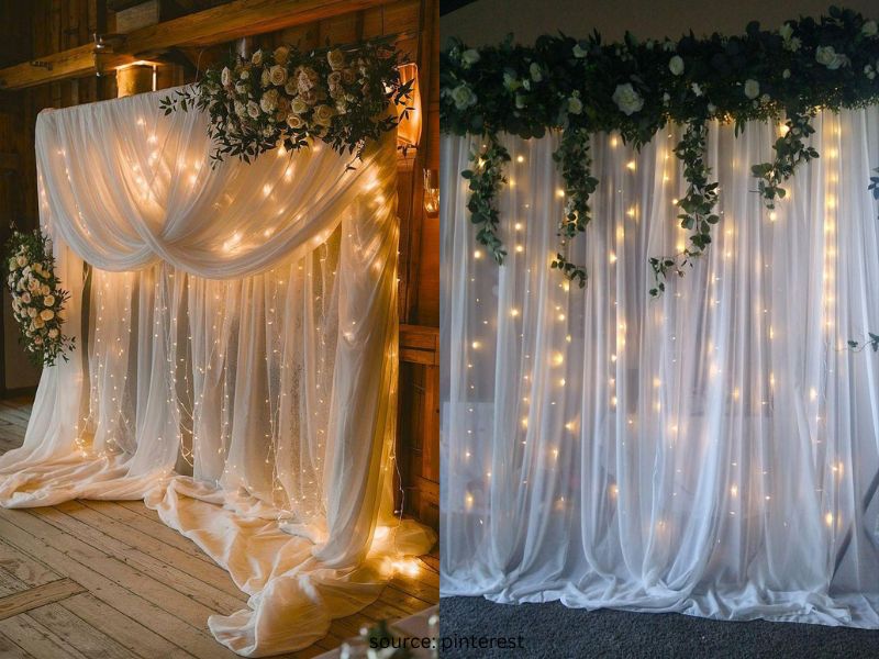 Fairy light wedding backdrop with sheer curtains creating a romantic reception atmosphere on a budget.