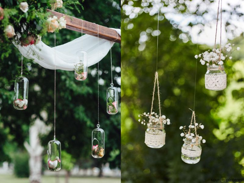 Hanging greenery and lantern decor filling vertical wedding reception space with romantic ambiance.