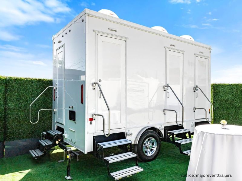 Luxury portable restroom trailer set up for outdoor wedding guests at outdoor venue.