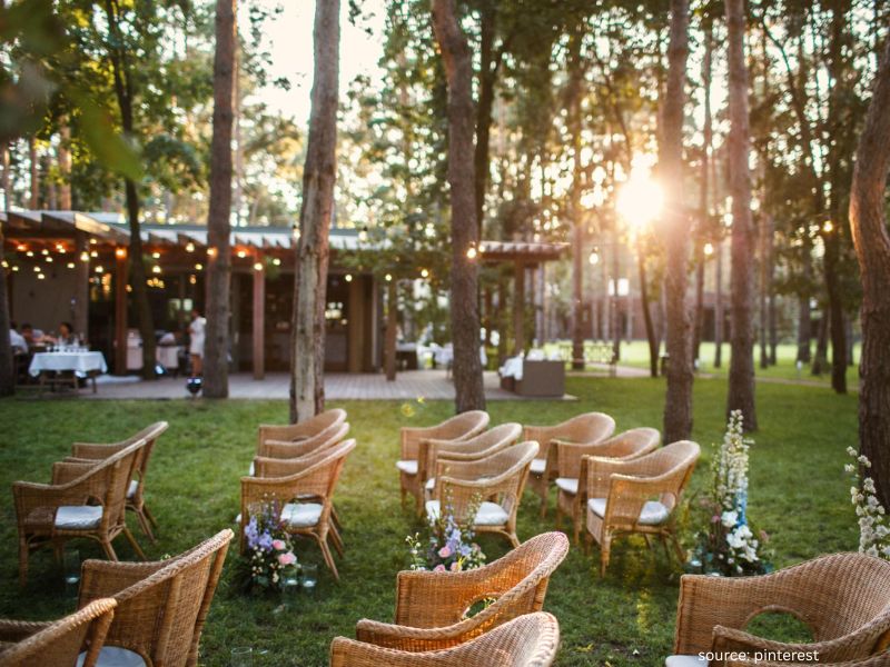 Romantic outdoor wedding ceremony during golden hour sunset with warm natural lighting.