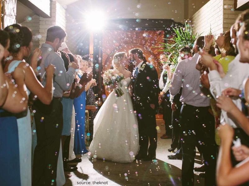 Romantic bubbles wedding exit at night with guests celebrating during the couple’s send-off.