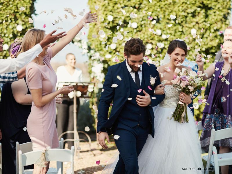 Happy couple laughing during candid outdoor wedding moment with natural imperfect atmosphere.
