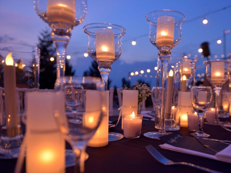 Candlelit backyard wedding tablescape with glowing lanterns and soft romantic lighting outdoors.