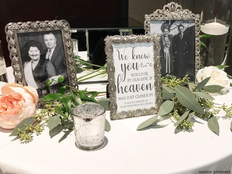 Wedding memory table with framed photos and candles honoring loved ones during the ceremony.