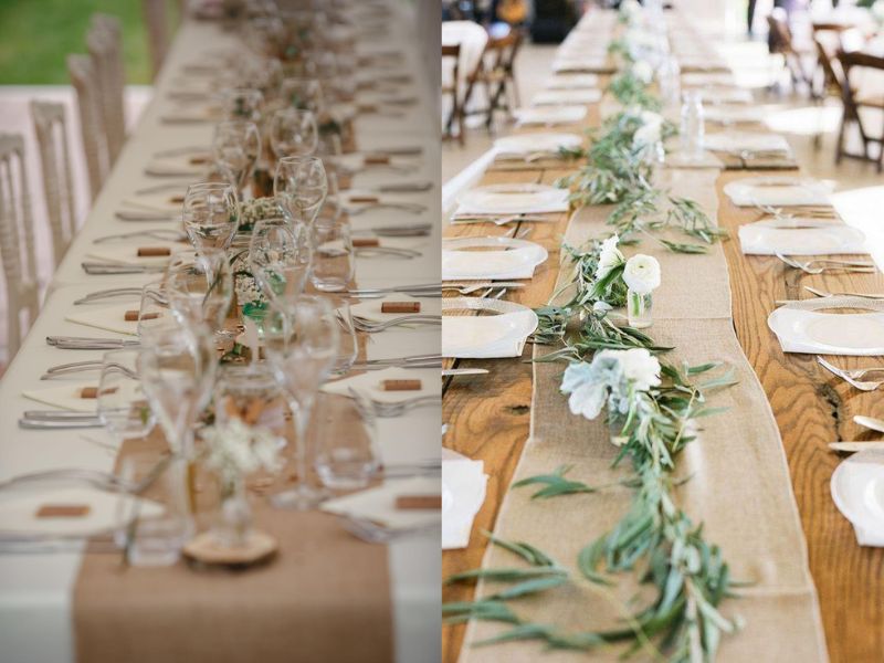 Long rustic farmhouse tables styled for an intimate backyard wedding reception with candles and greenery.