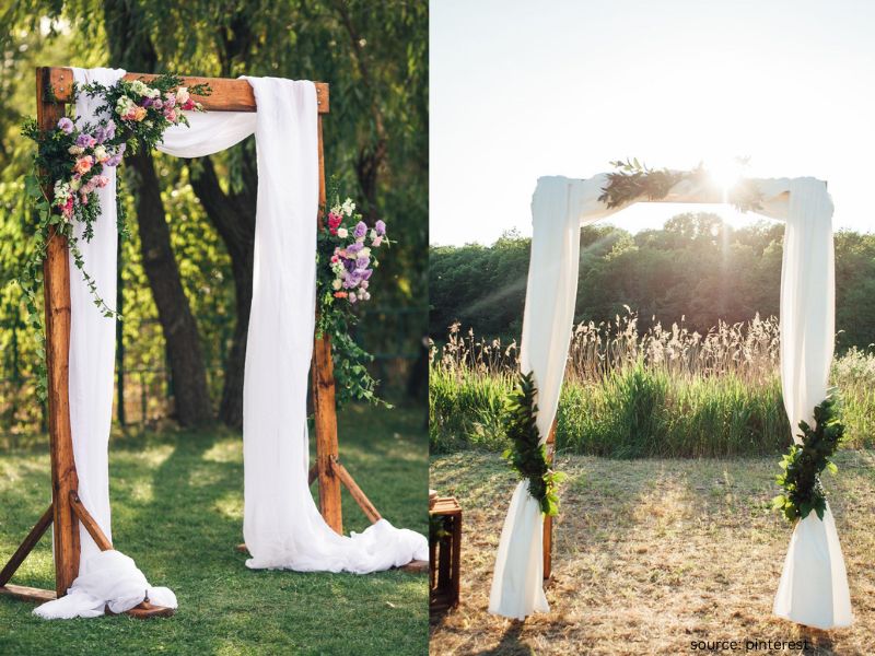 Rustic wooden wedding arch decorated with greenery and fabric for an intimate outdoor ceremony.