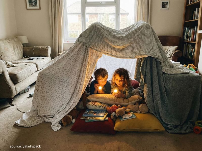 Kids building a cozy blanket fort for screen-free indoor play