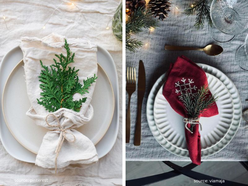 Small greenery sprig placed across a napkin at a Christmas table setting.