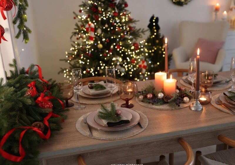 Cozy Christmas table setting with greenery, candles, and simple dinnerware.